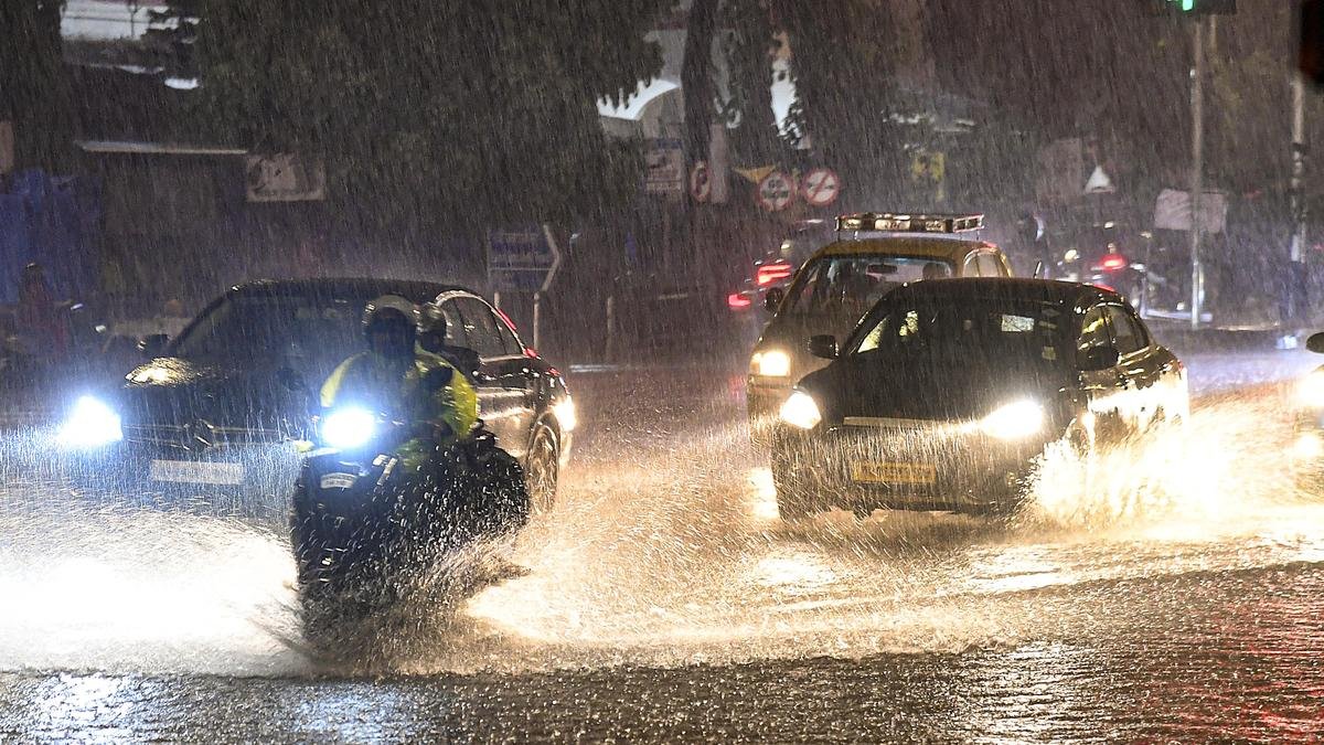 Commuters wade through a waterlogged road amid heavy rainfall, in Mumbai, Maharashtra.