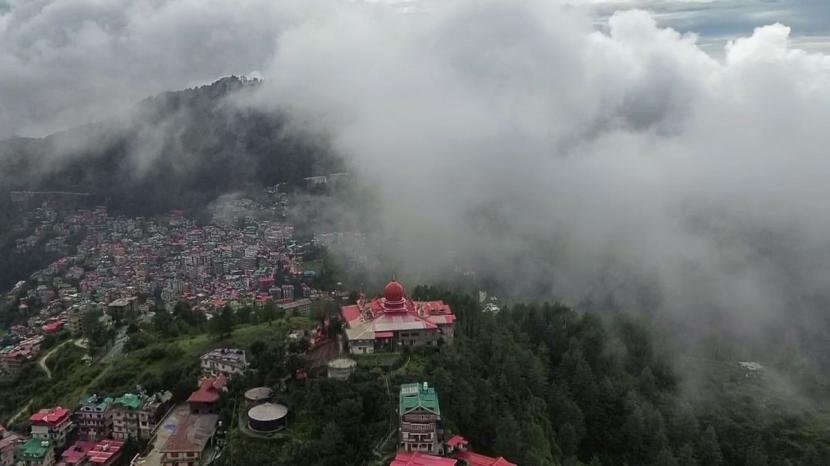 Dense fog and clouds engulf the hill station amid a red alert for heavy rainfall issued by IMD, in Shimla on Tuesday.